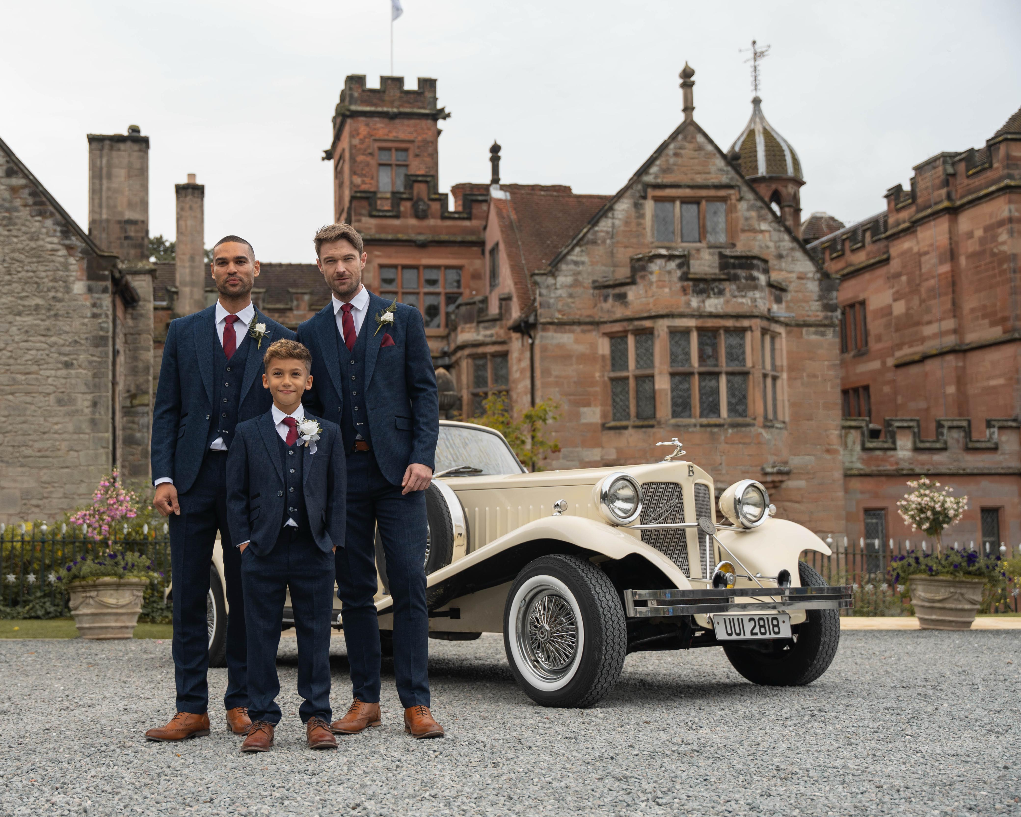 Groomsmen and a pagboy wearing matching sustainable formalwear to a wedding.