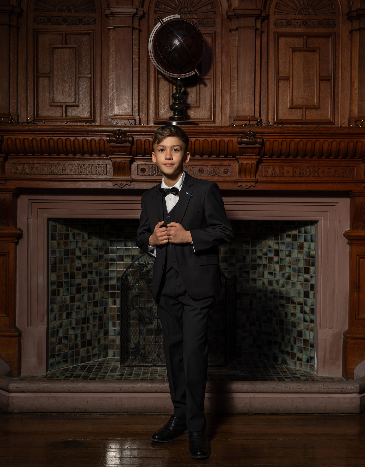A boy wearing a 5-piece tuxedo for a winter wedding