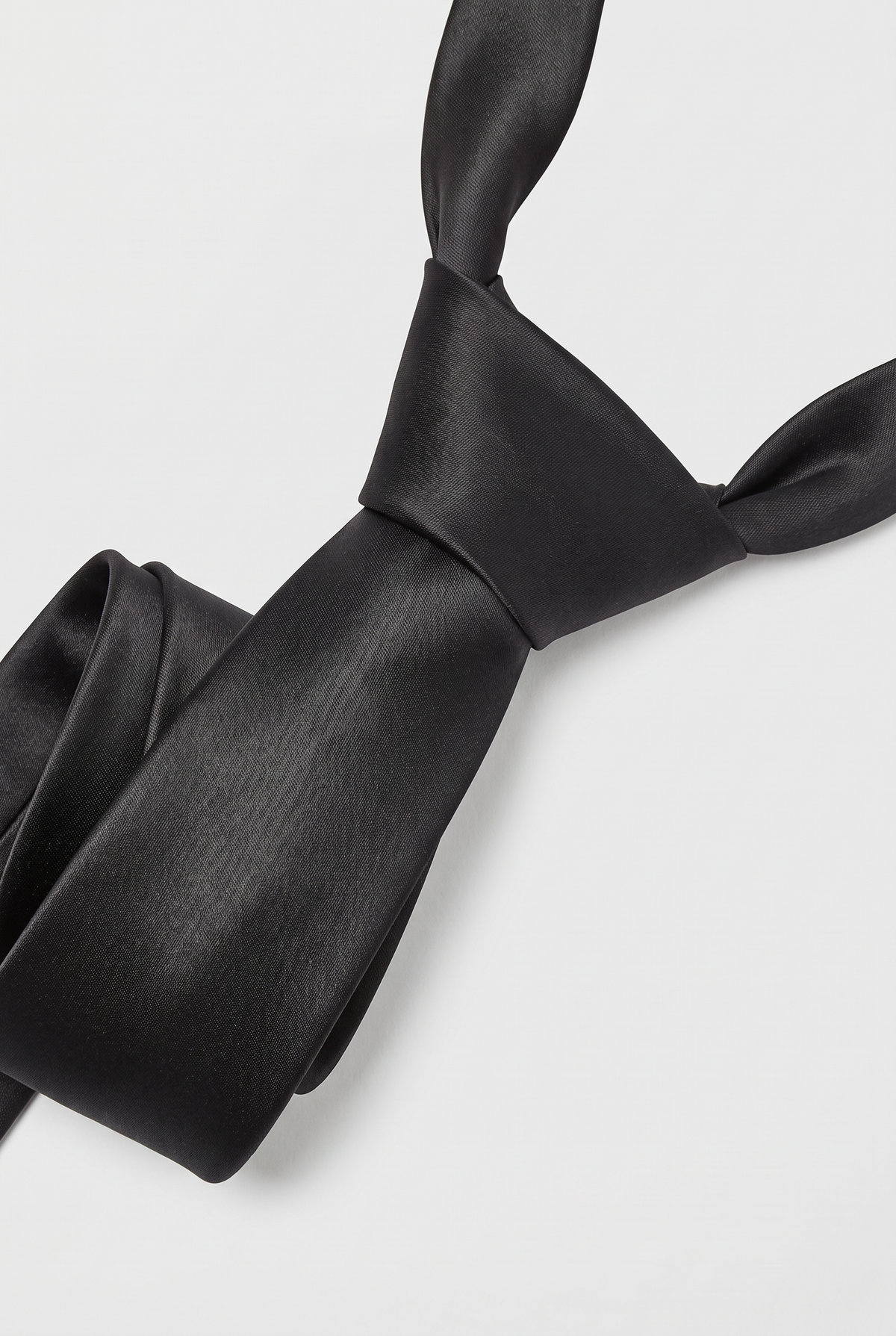 Black satin necktie showing knot and fabric texture close-up