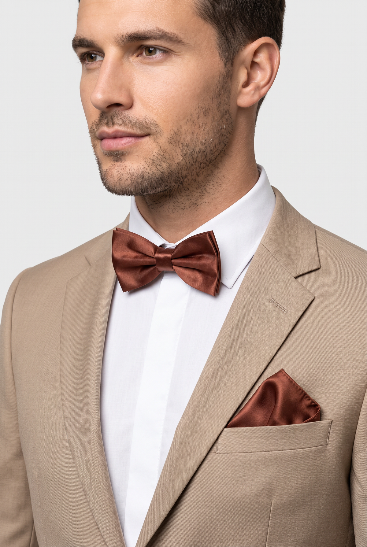 Men wearing a brown satin bow tie and matching pocket square with a suit