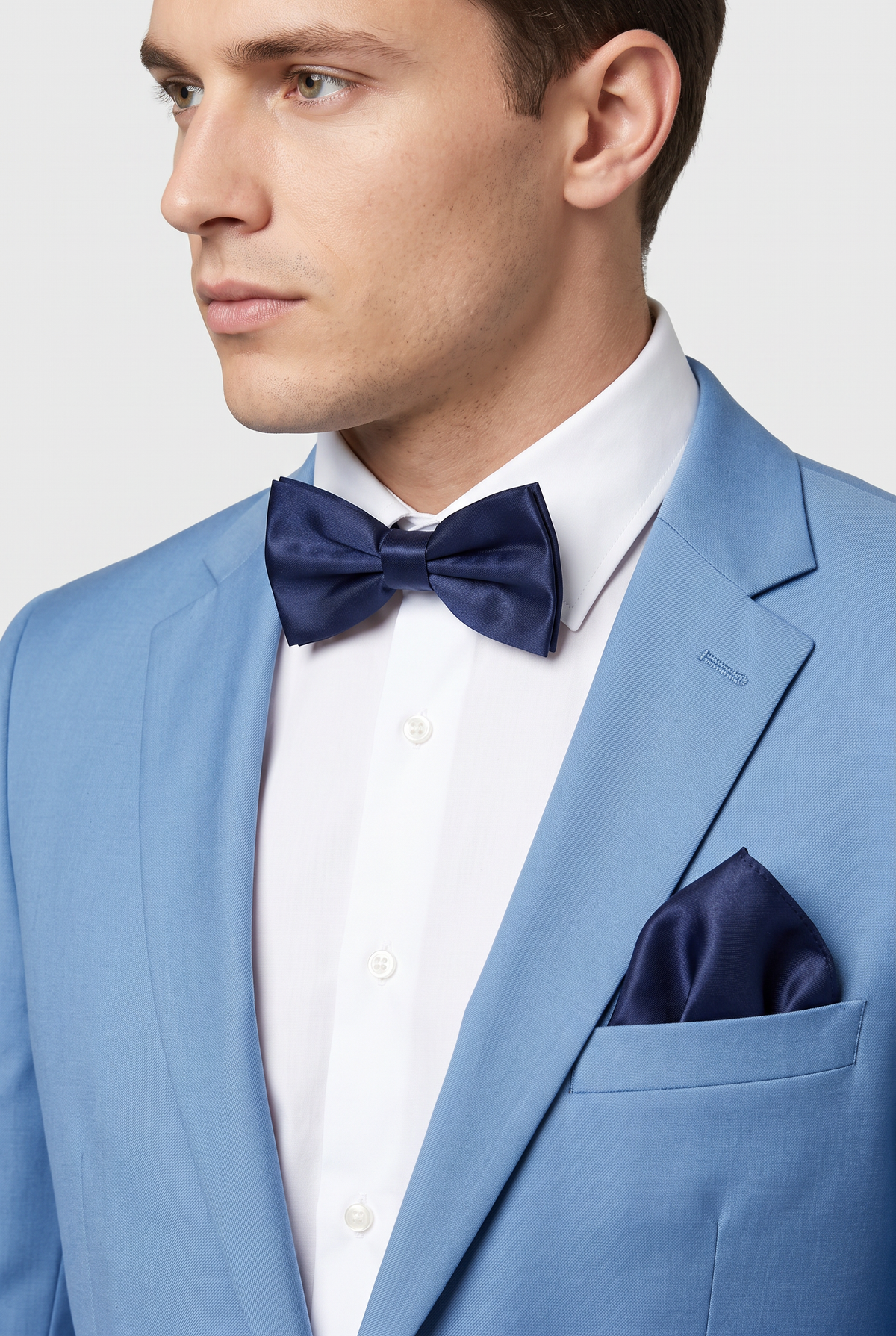 Men wearing a navy satin bow tie and matching pocket square with a suit