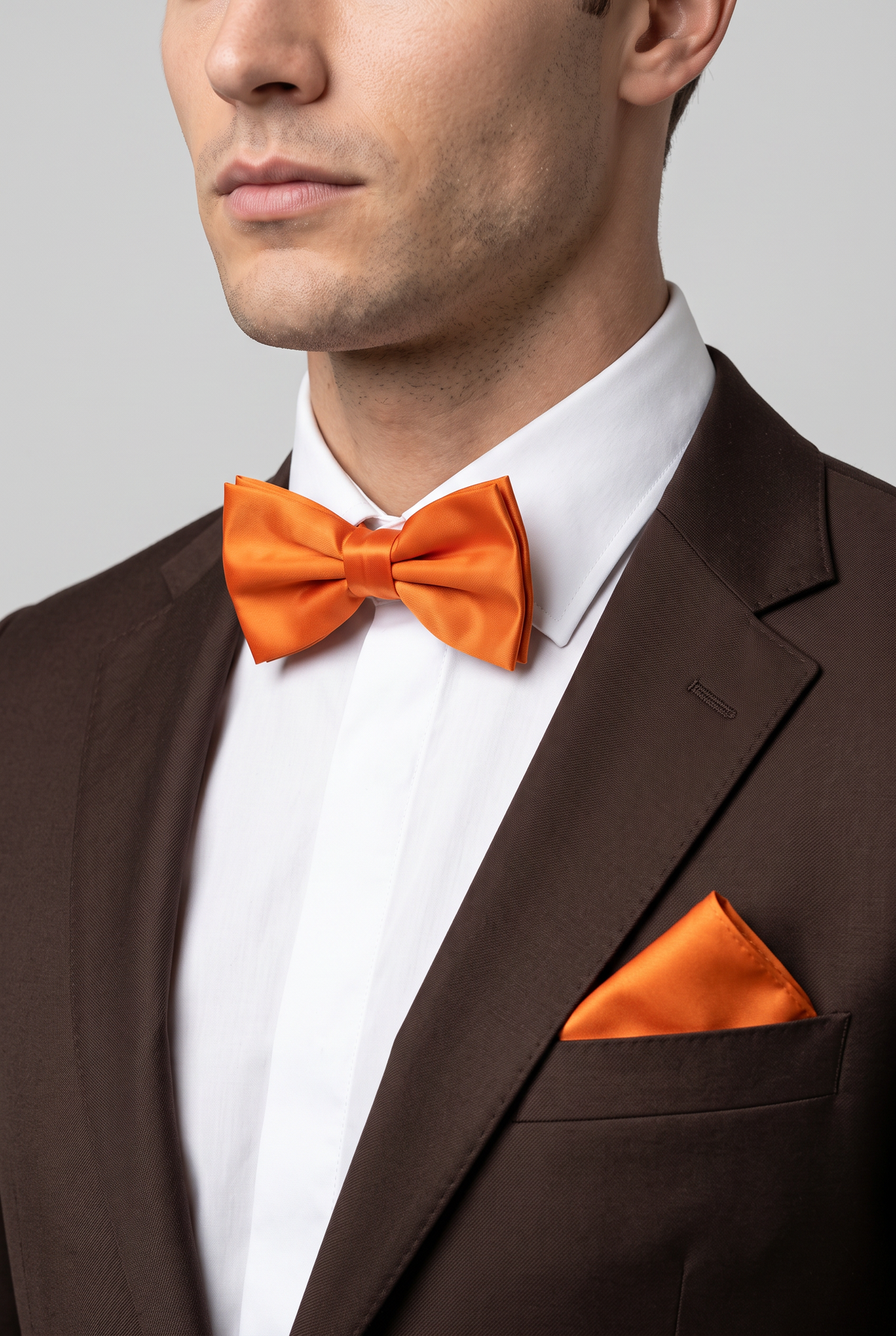 Men wearing a Orange satin bow tie and matching pocket square with a suit