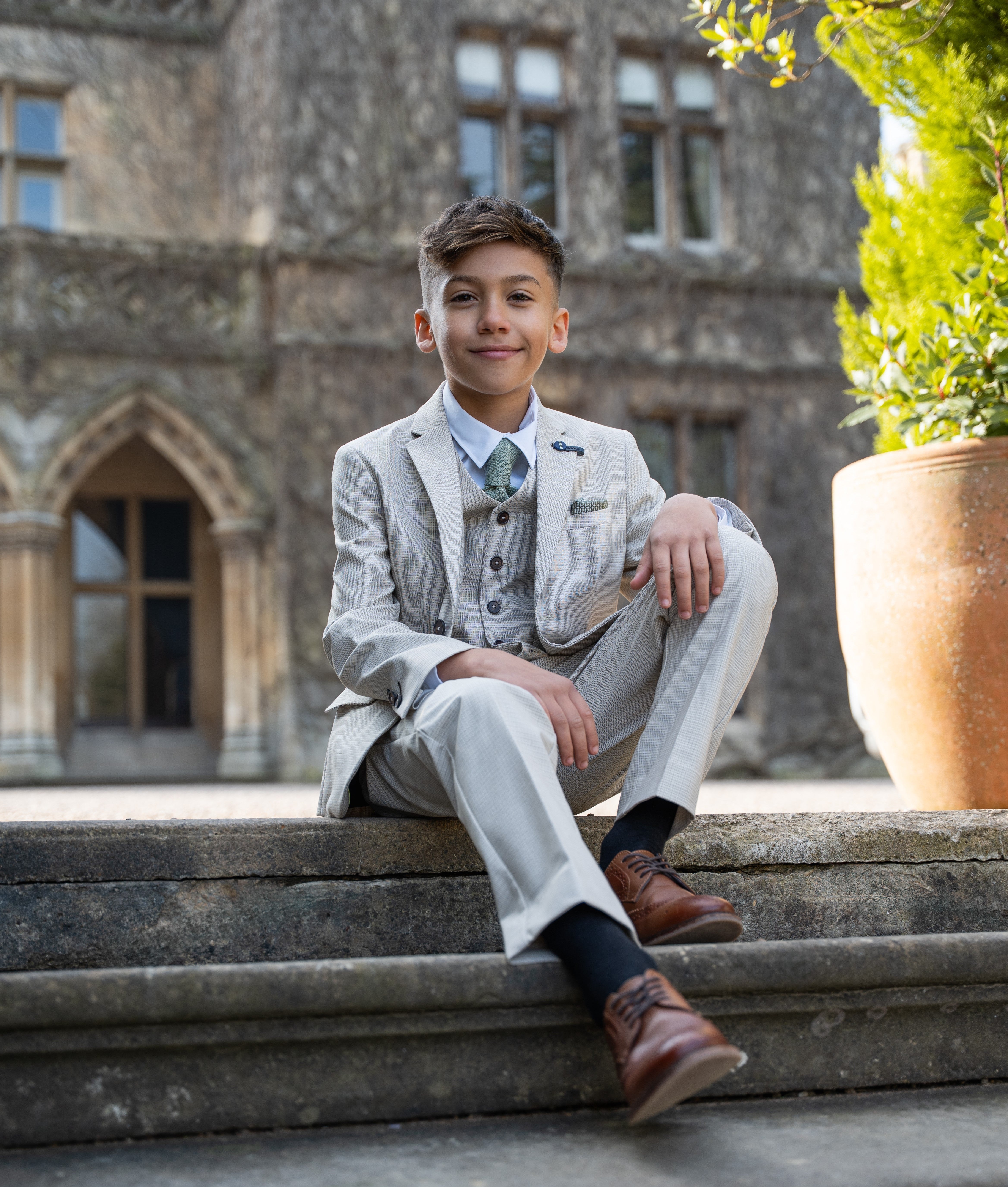 A boy wearing a summer suit as a wedding guest 