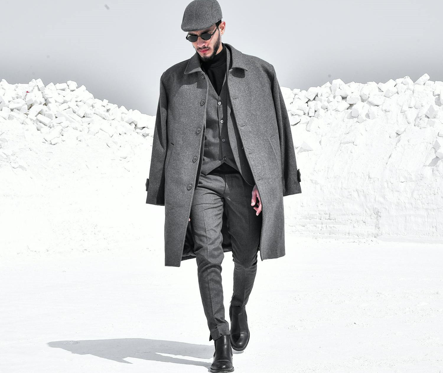 A Man in Gray Suit and Dress Boots Walking on Snow Covered Ground.