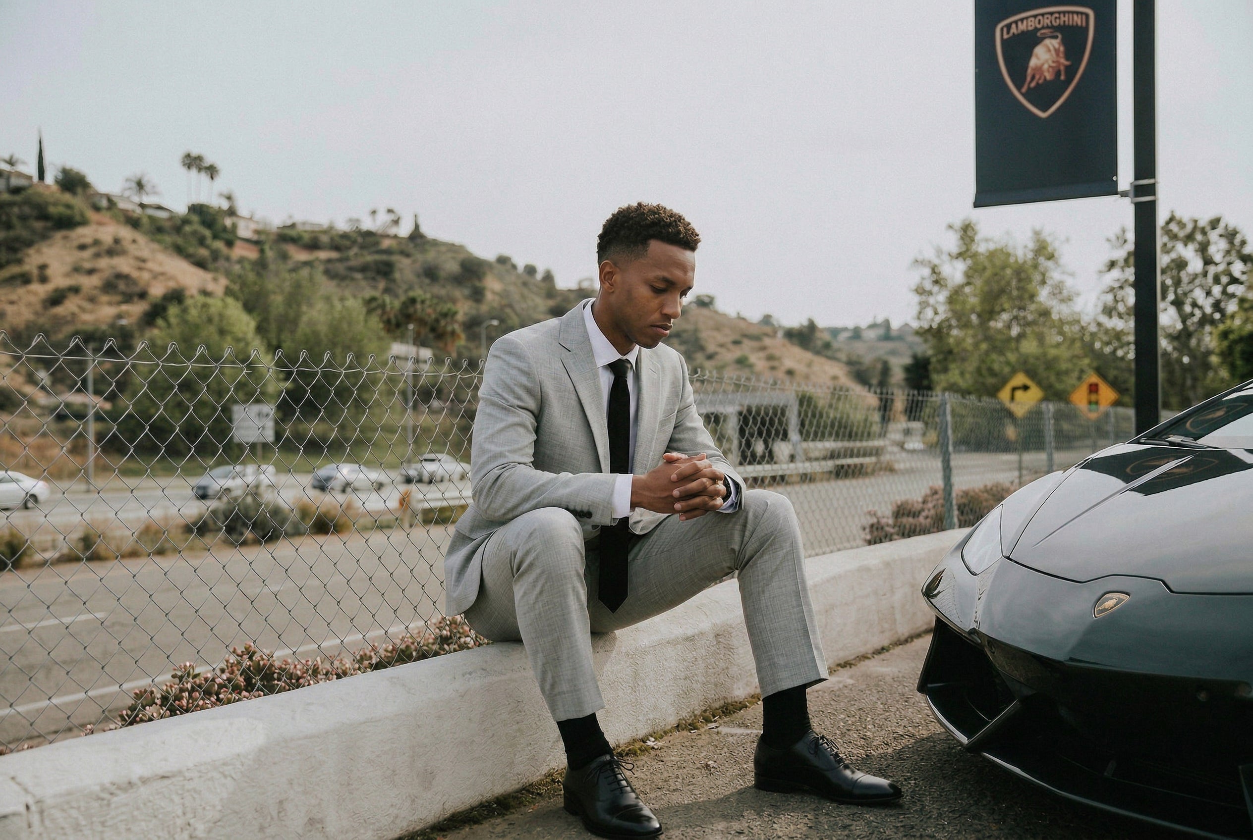 A young man wearing a two-piece prom suit posing in a parking lot