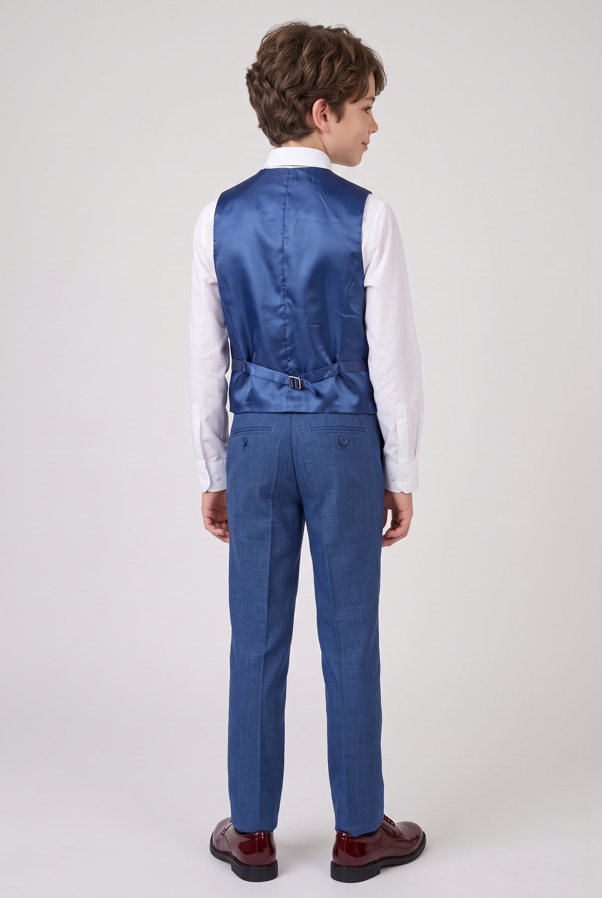 Back view of boy wearing navy suit vest and trousers