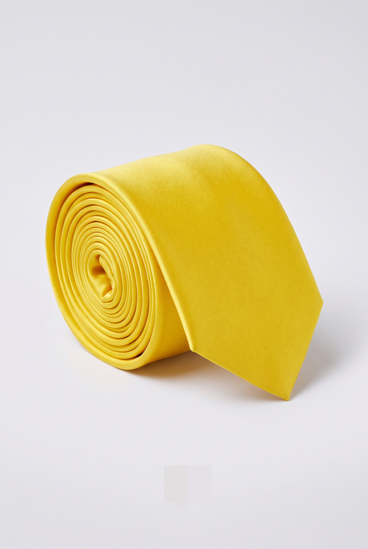 Yellow satin men's necktie, rolled close-up view