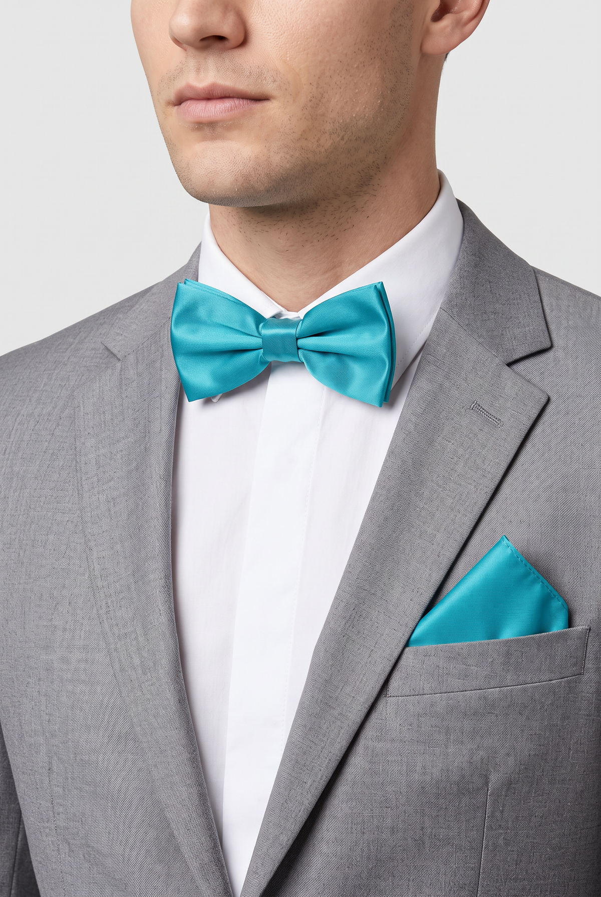Men wearing a aqua satin bow tie and matching pocket square with a suit
