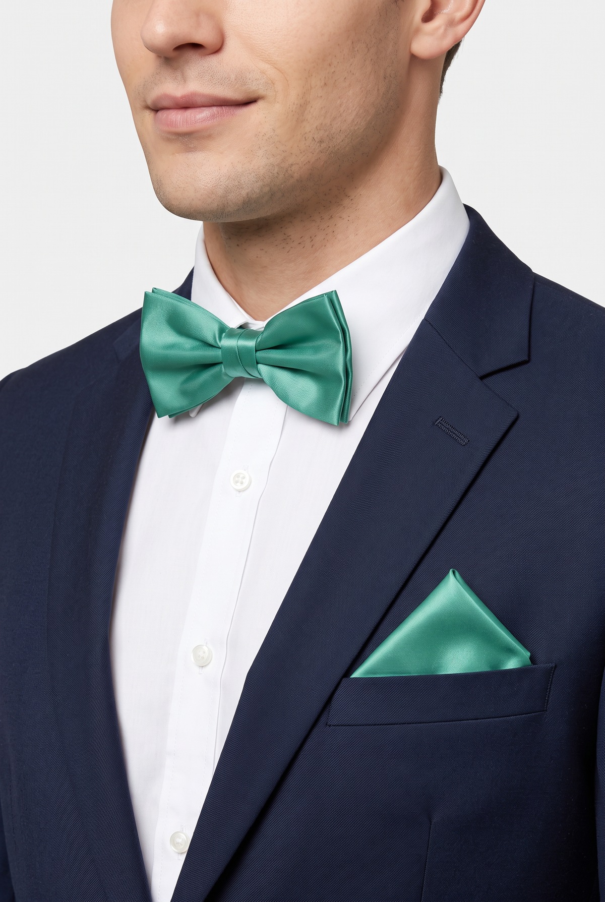 Men wearing a green satin bow tie and matching pocket square with a suit