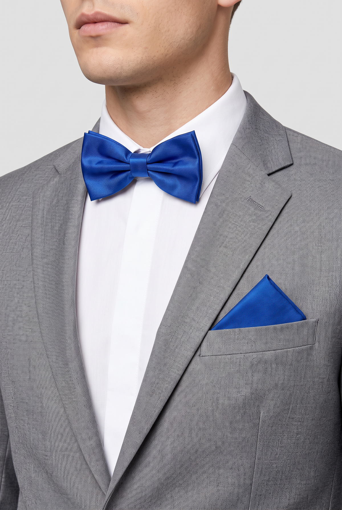 Men wearing a royal blue satin bow tie and matching pocket square with a suit